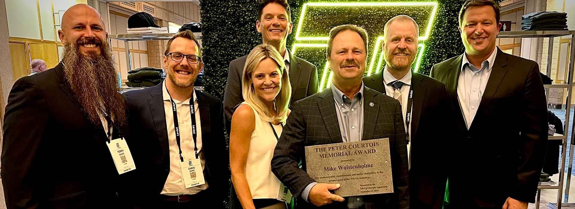 Photo of Mike Wolstenholme holding award plaque